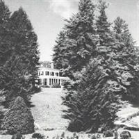 Old black and white photo, clubhouse with ancient Greek architecture, surrounded by trees