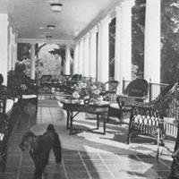 old sepia photo of the clubhouse porch with outdoor lounge chairs and tables