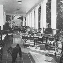 old sepia photo of the clubhouse porch with outdoor lounge chairs and tables