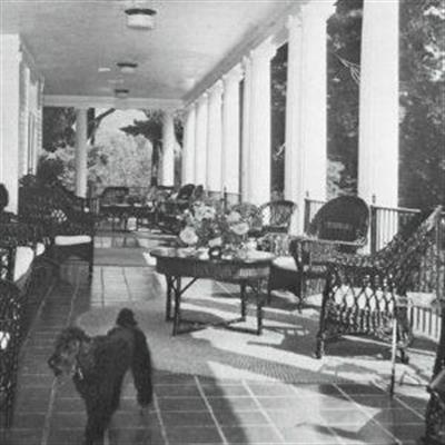 old sepia photo of the clubhouse porch with outdoor lounge chairs and tables